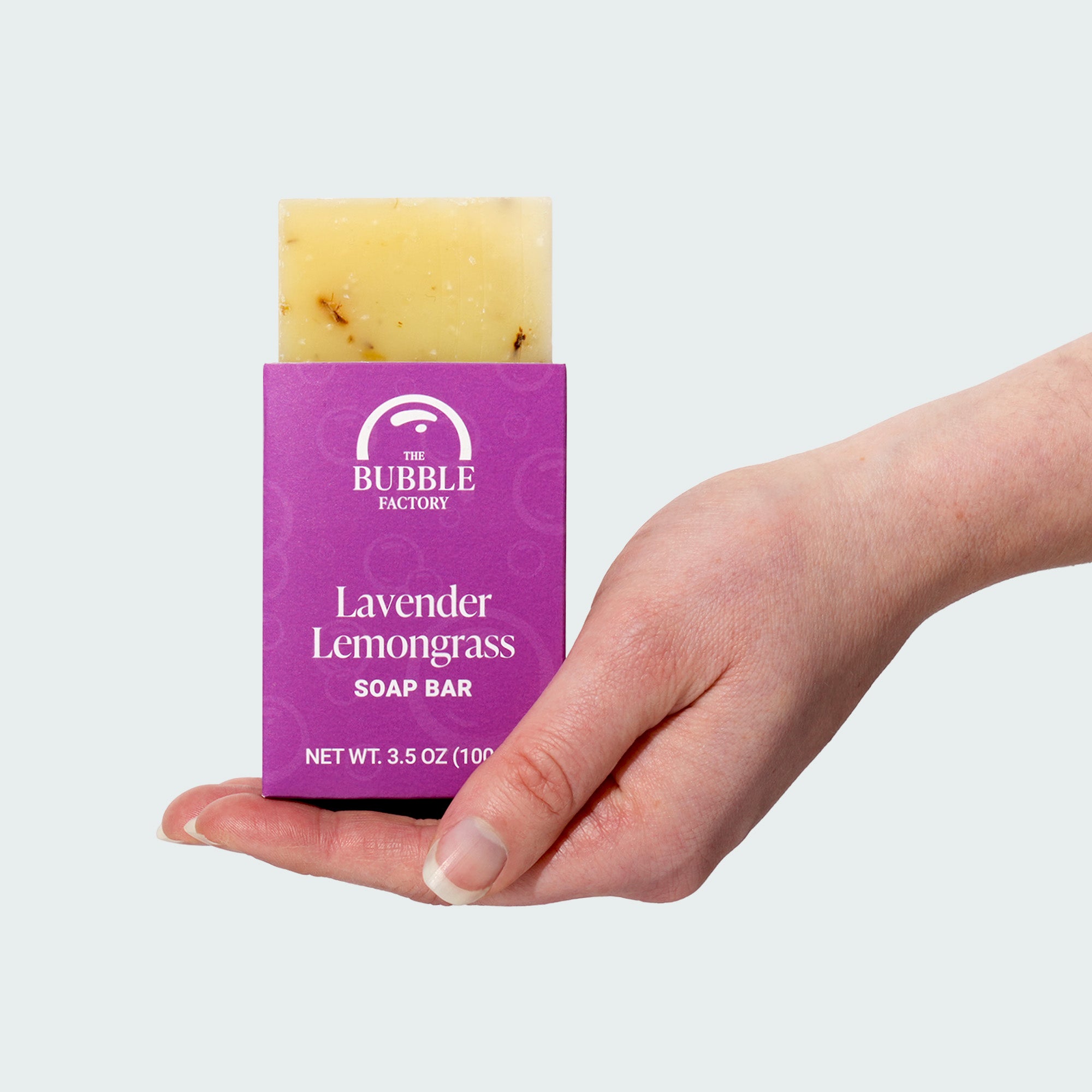 Hand holding a bar of Lavender Lemongrass Natural Essential Oil Soap Bar