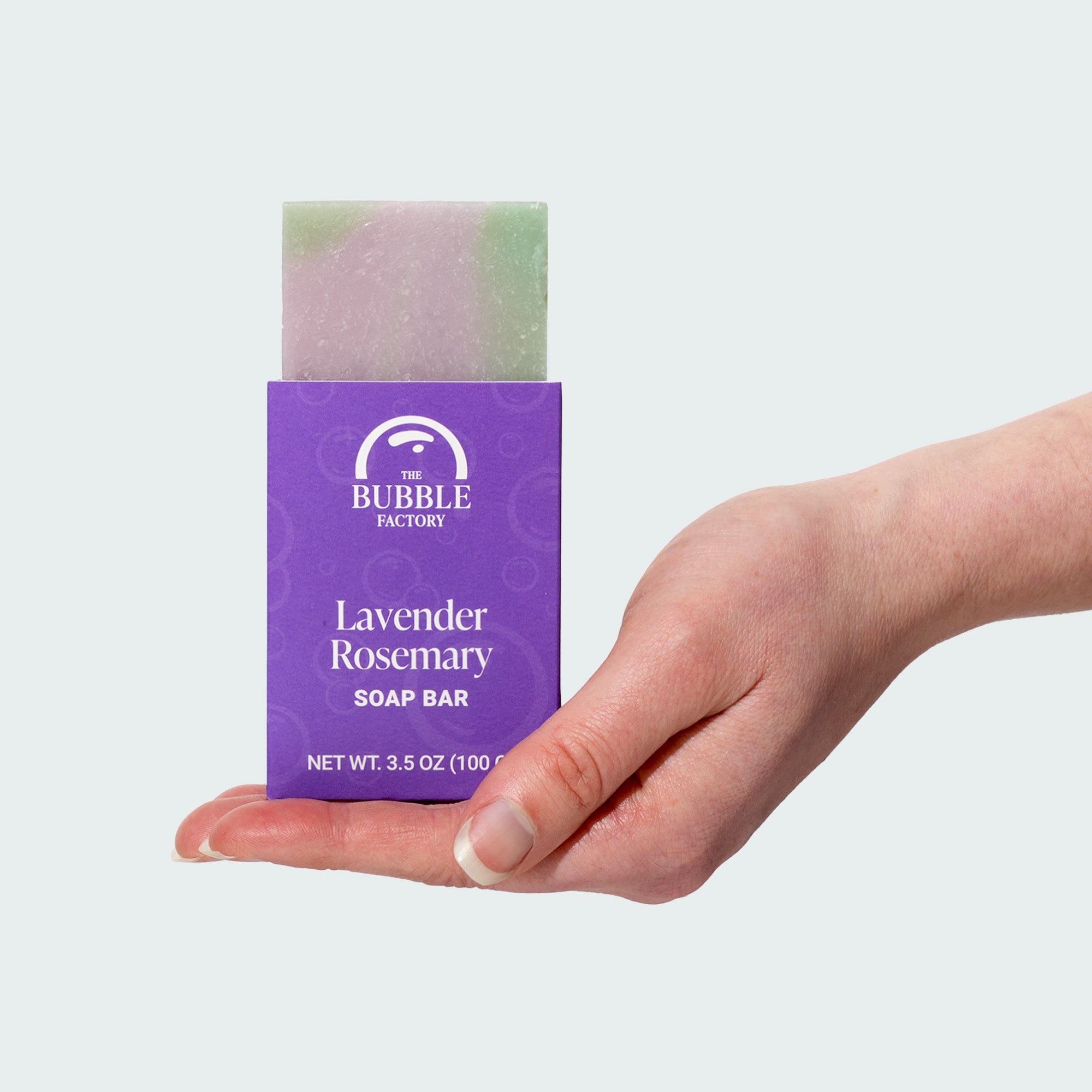 Hand holding a bar of Lavender Rosemary Natural Essential Oil Soap Bar